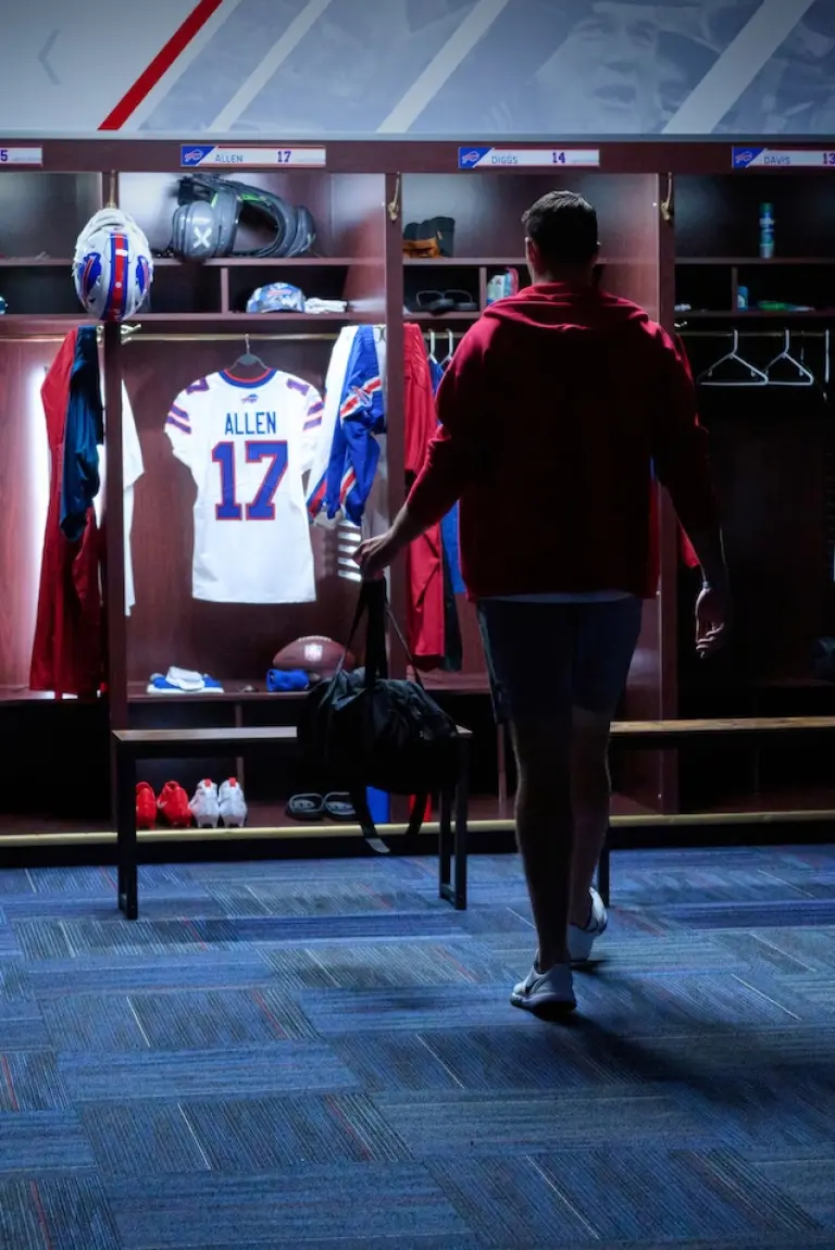 Josh Allen in the locker rook looking at his jersey